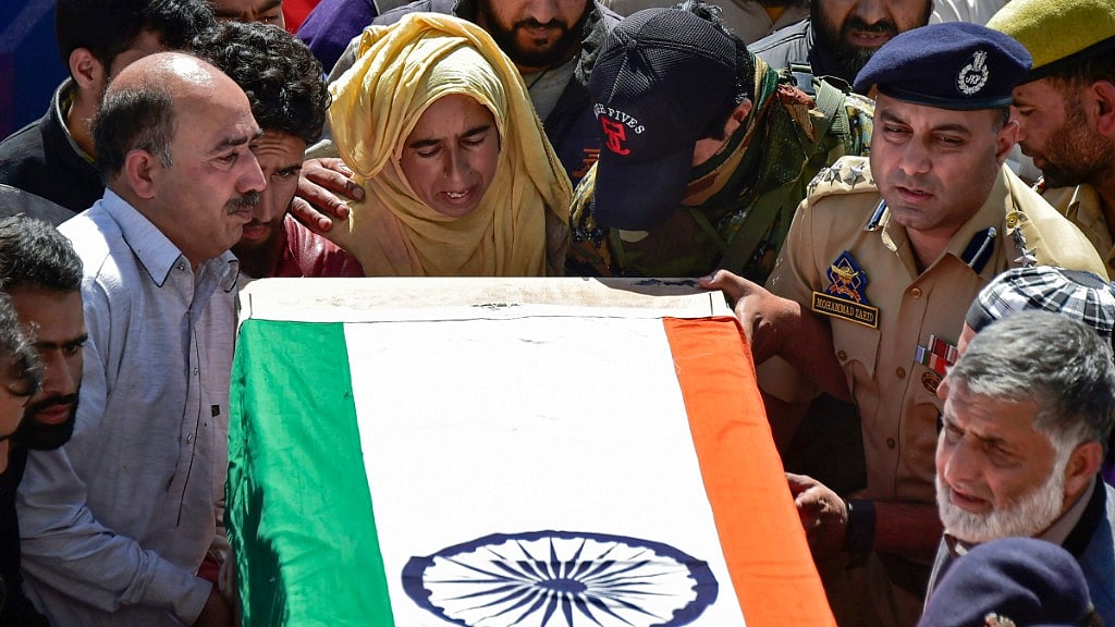 A woman relative and police officers shoulder the coffin of slain police constable Nissar Ahmad Dhobi after a wreath-laying ceremony in Shopian on Friday, 21 September, 2018. The militants had abducted three SPOs and killed them.