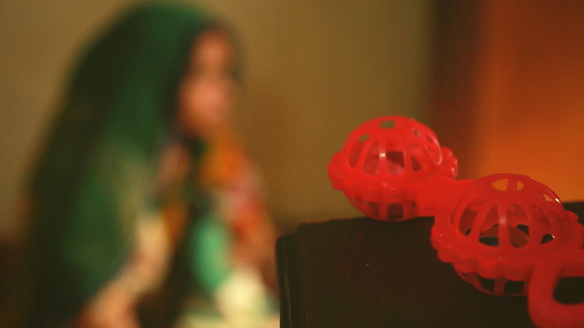A photograph of the eight-month-old rape survivor’s mother (in the background).