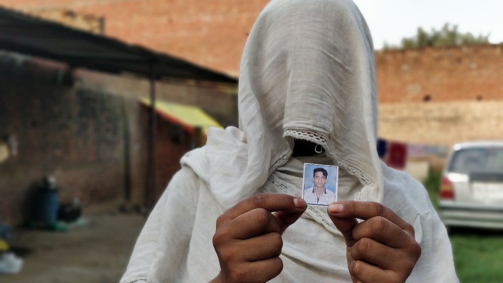 Mustakeen’s wife holds a picture of her slain brother-in-law, Naushad.