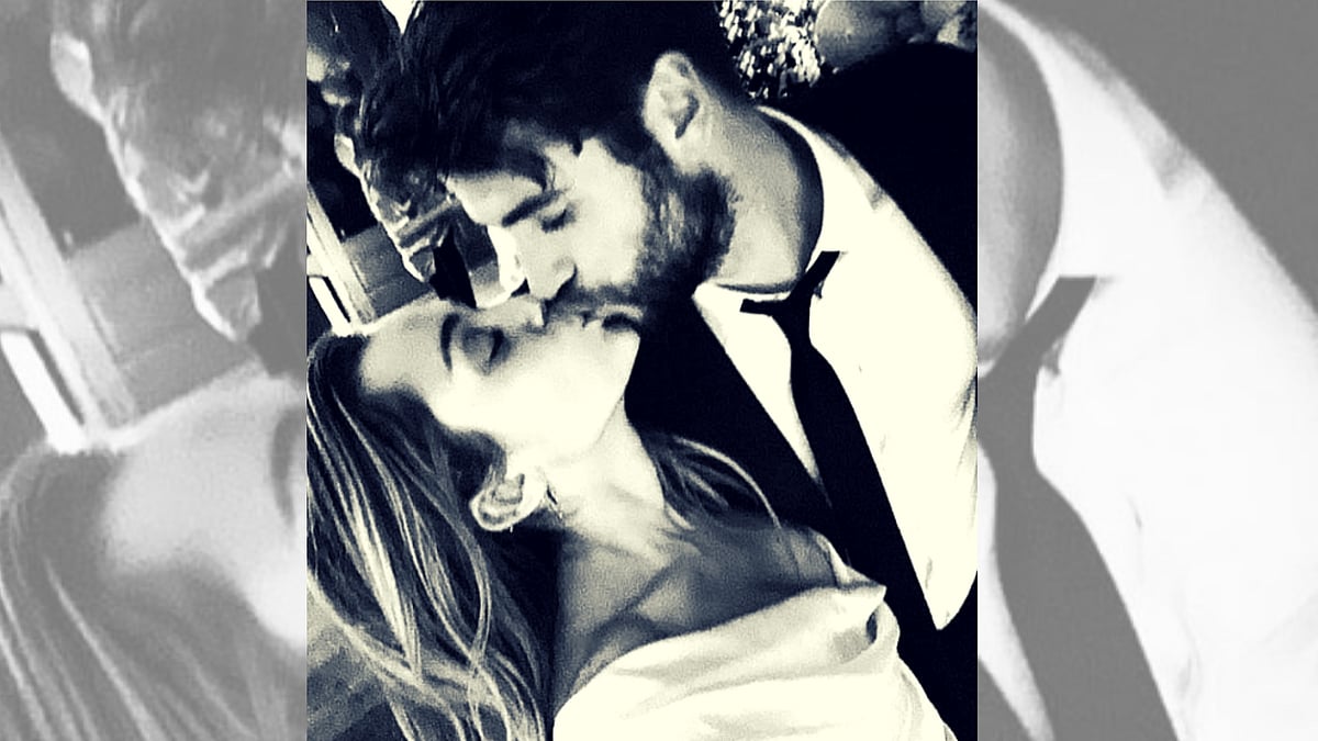 Miley Cyrus and husband Liam Hemsworth share a kiss. 