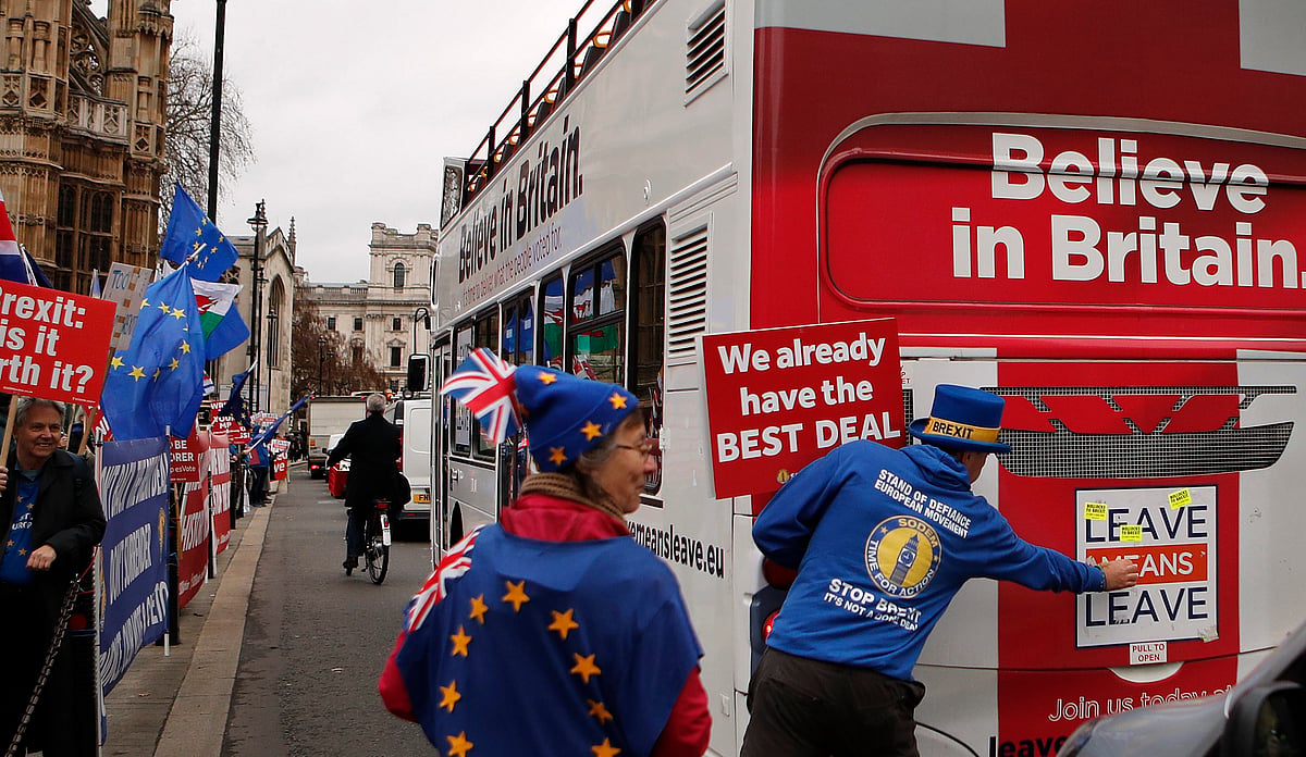 File photo of Anti Brexit demonstrators put stickers on a bus during a protest outside the Houses of Parliament in London Thursday Dec. 6, 2018. 
