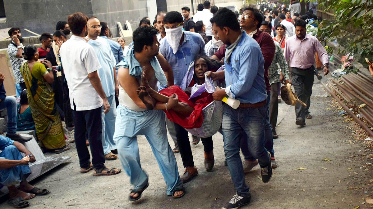 People carry the injured during a rescue operation after a major fire broke out at ESIC Kamgar Hospital, in Mumbai, on 17 December.