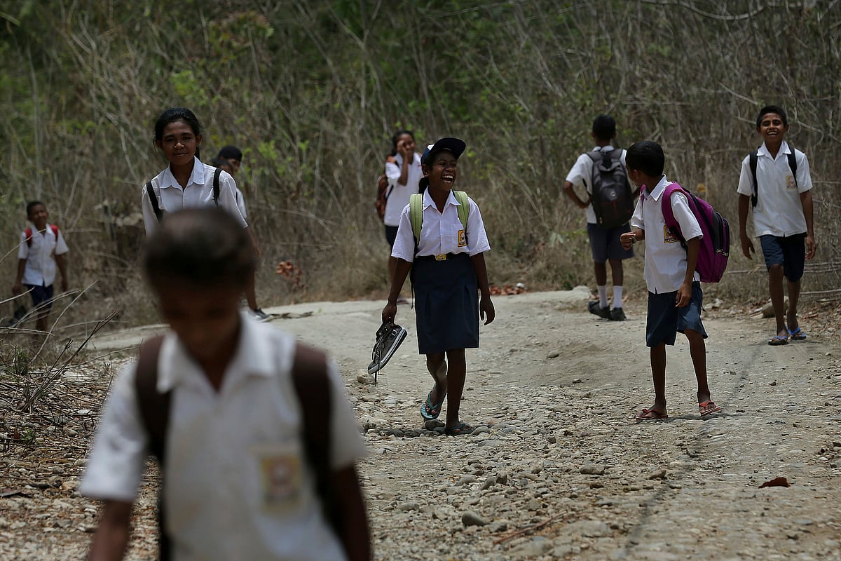  Students walk on a dirt road after school in West Timor, Indonesia. Children in this impoverished region of Indonesia often must walk long distances to school.
