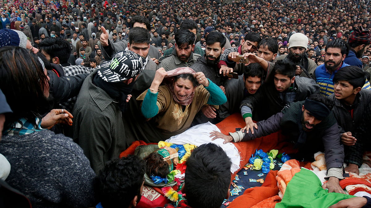 An unidentified relative weeps near the body of Mudasir Rashid Parray during joint funeral of teenage rebels Saqib Bilal Sheikh and Parray at Hajin village, north of Srinagar, Kashmir, on Monday, 10 December. Thousands of people in Kashmir joined the funeral procession of the rebels killed over the weekend in a long gun battle with Indian troops in the disputed region.
