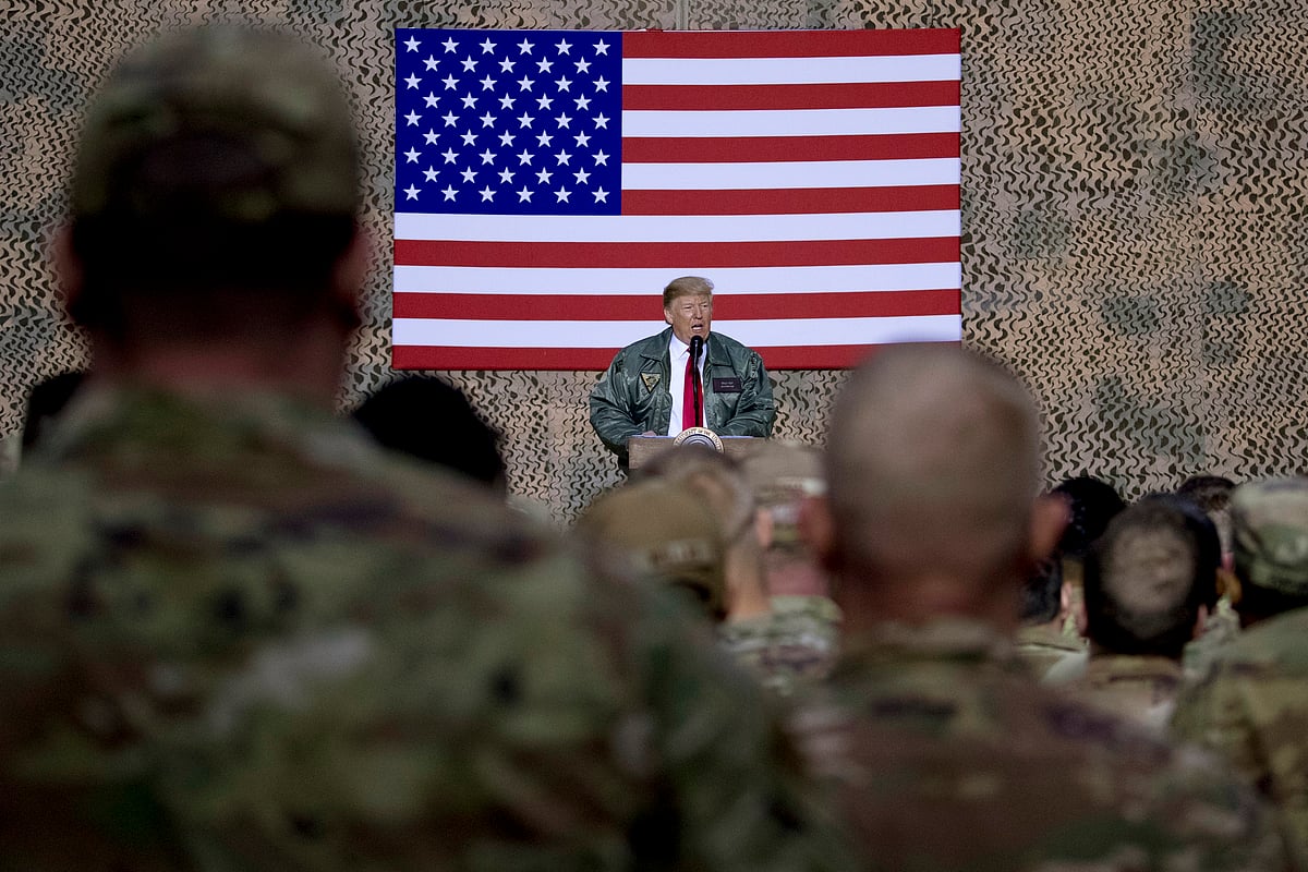 In this 26 December 2018, file photo, President Donald Trump speaks to members of the military at a hangar rally at Al Asad Air Base, Iraq.