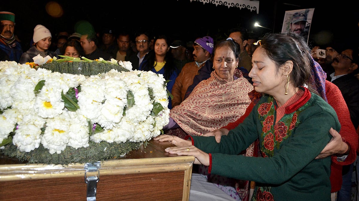 Wife Nitika Kaul of Major Vibhuti Shankar Dhoundiyal, who was martyred in Pulwama encounter with Jaish-e-Mohammed (JeM) terrorists, mourn near his mortal remains which were brought to his home in Dehradun on Monday. 