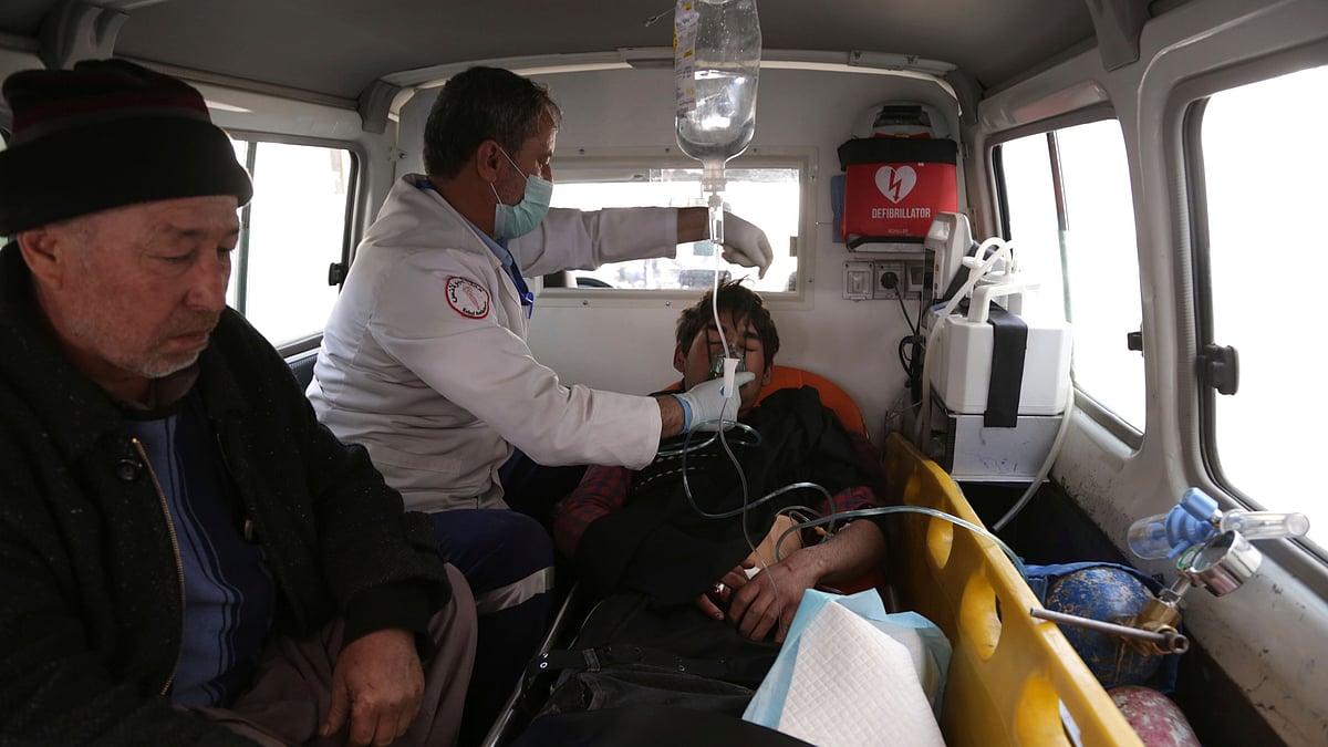 Afghans treat an injured man in an ambulance, in Kabul, Afghanistan.