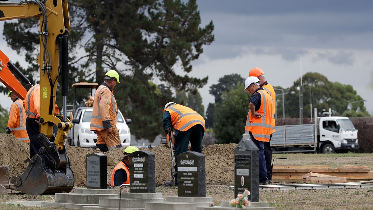 Workers dig graves at a Muslim cemetery in Christchurch, New Zealand, Saturday, 16 March 2019, for victims of a mass shooing at two area mosques.