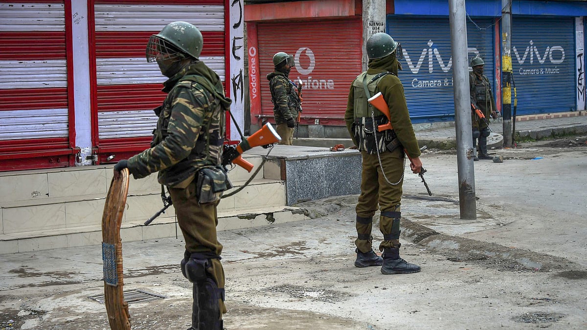 Security personnel stand guard during restrictions in Srinagar on 1 March. 