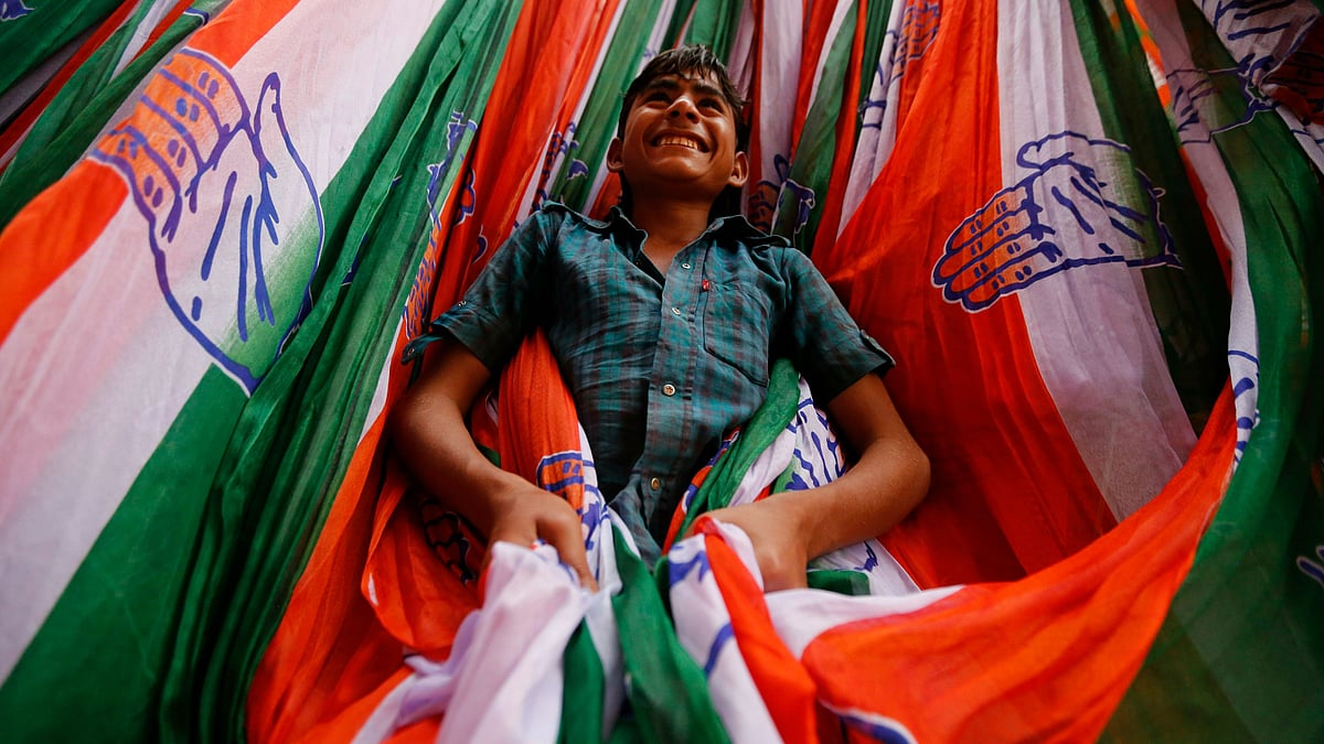 A child plays amidst election campaign material of the Congress party for the upcoming elections in Ahmedabad.