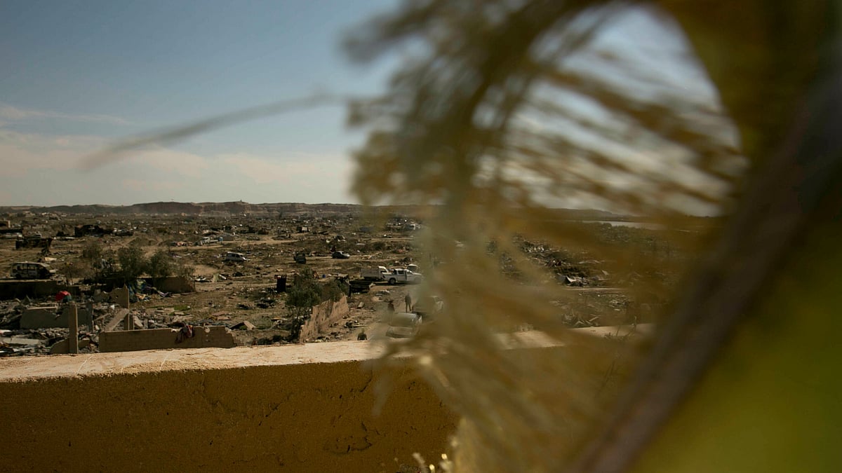 US-backed Syrian Democratic Forces (SDF) fighters fly their flag from a rooftop overlooking Baghouz in Syria after the SDF declared the area free of Islamic State militants after months of fighting on Saturday, 23 March, 2019.