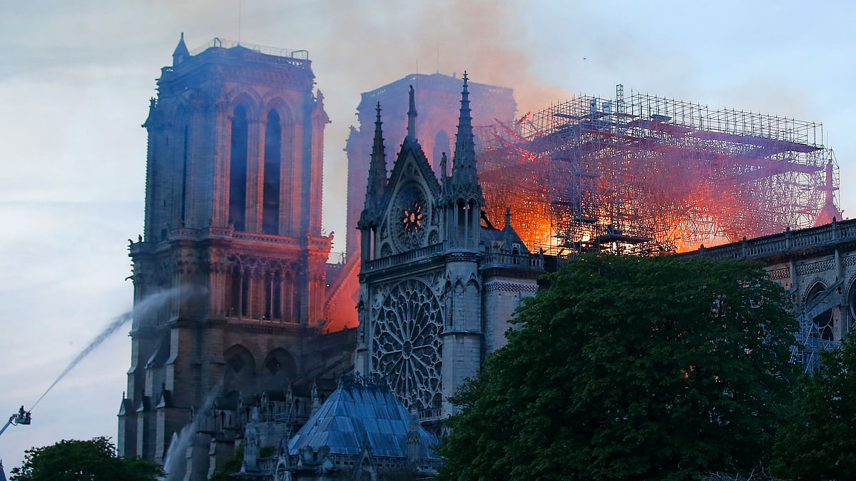 A firefighter tackles the blaze as flames and smoke rise from Notre Dame cathedral as it burns in Paris.