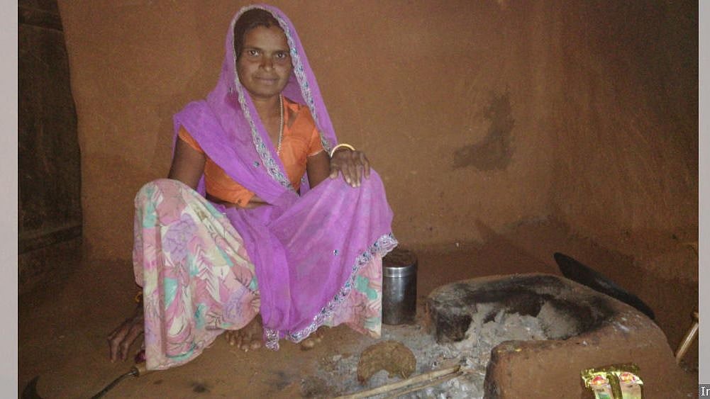 Goti Bai with her earthen chulha used for everyday cooking. She received a gas stove, cylinder and regulator under PMUY but cannot afford a refill.