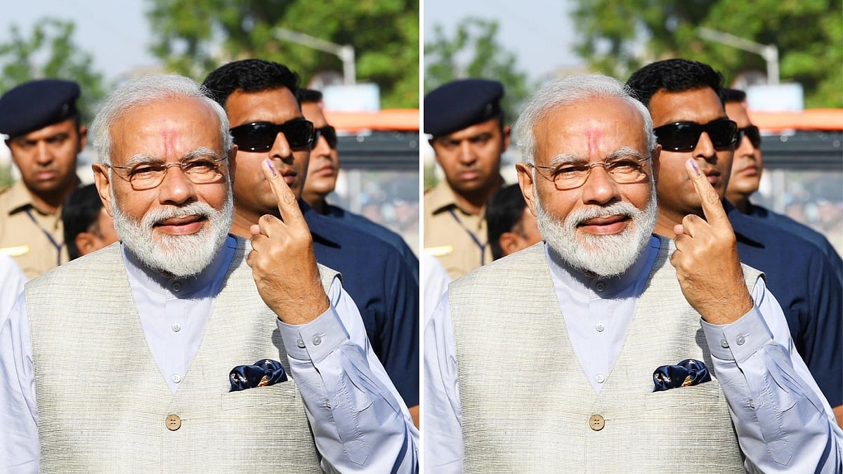 PM Modi shows his inked finger after casting his vote.