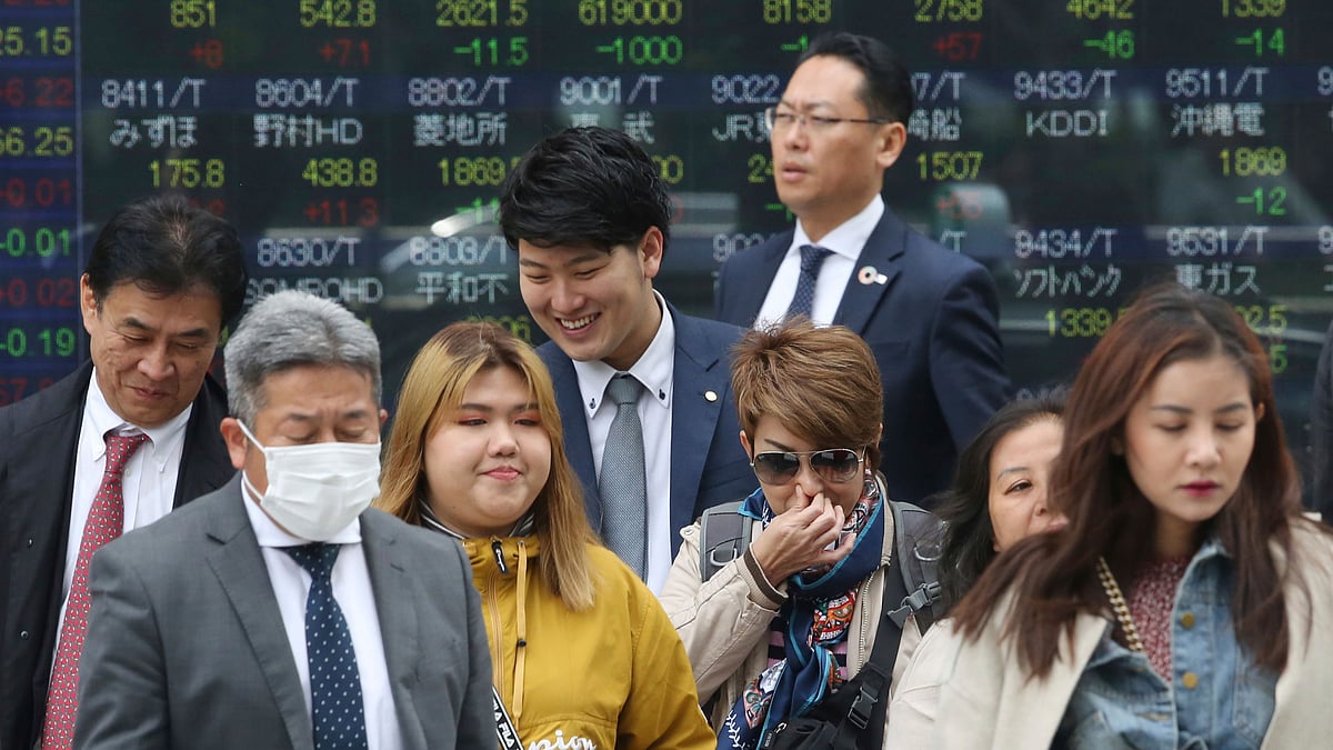 People in front of an electronic stock board of a securities firm in Tokyo