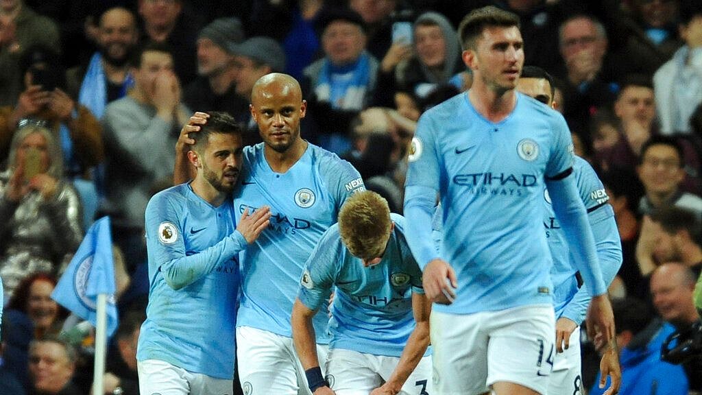 Manchester City captain Vincent Kompany celebrates his goal with teammates.