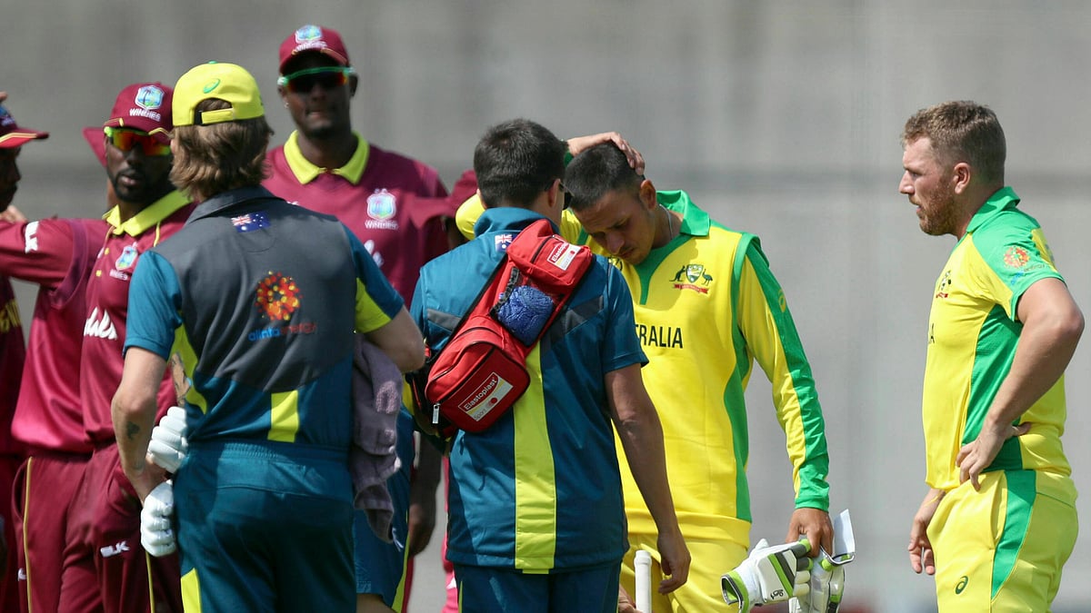Australia’s Usman Khawaja (2nd right) rubs his head after being hit by a bouncer by West Indies’ Andre Russell during the World Cup warm-up match at the Nursery Ground, Southampton, England, Wednesday May 22, 2019. 