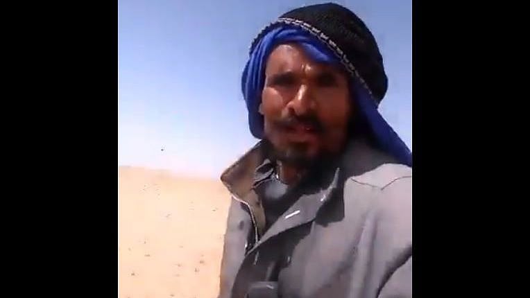 An Indian worker from Telangana (pictured above) can be seen isolated in a desert in Saudi Arabia, with only a few camels around.