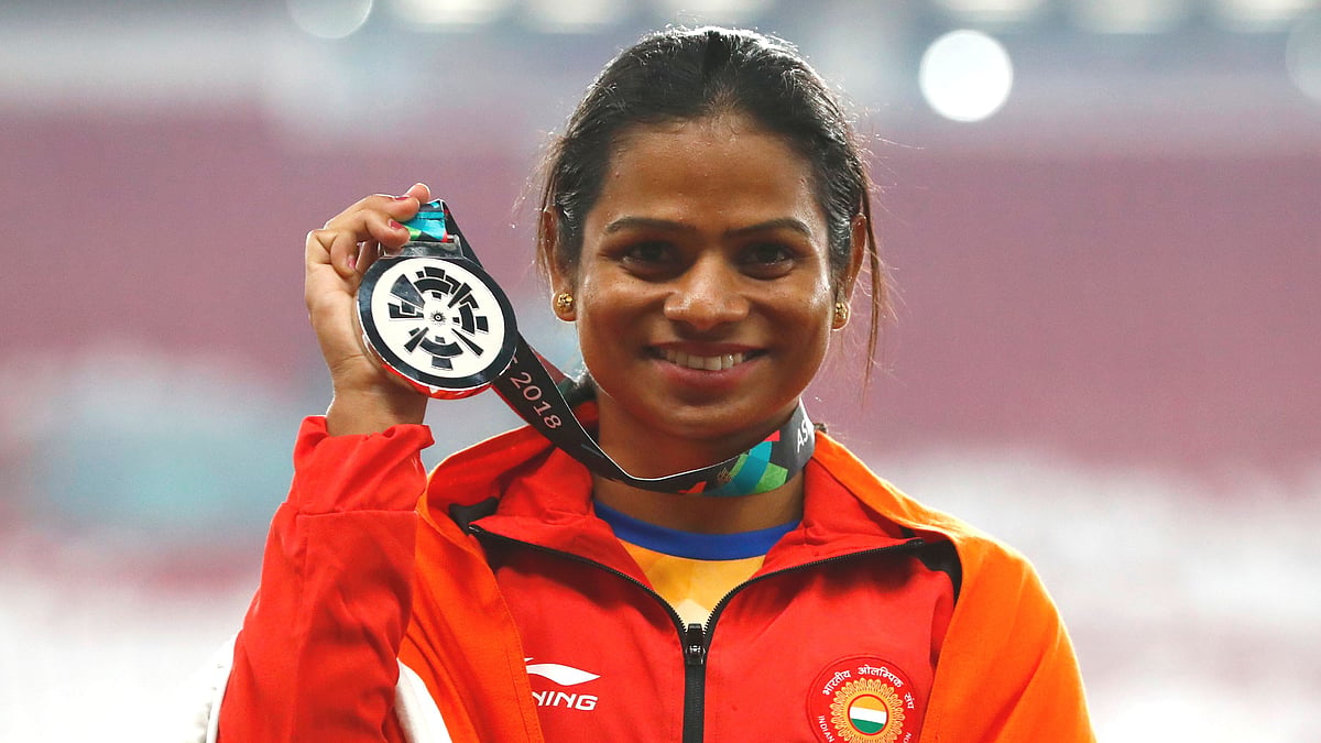 India’s Dutee Chand celebrates on the podium after winning the silver medal in the women’s 100m final during the athletics competition at the 18th Asian Games in Jakarta, Indonesia.