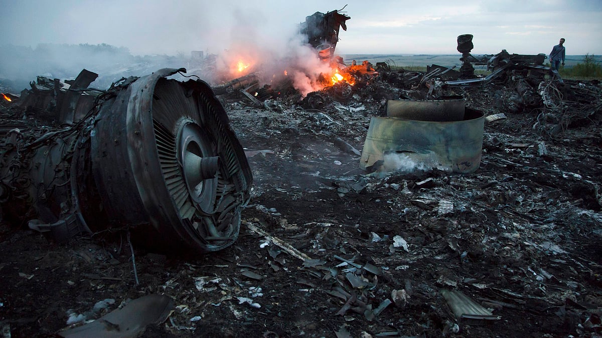 A man walks amongst the debris at the crash site of a passenger plane near the village of Hrabove, Ukraine.