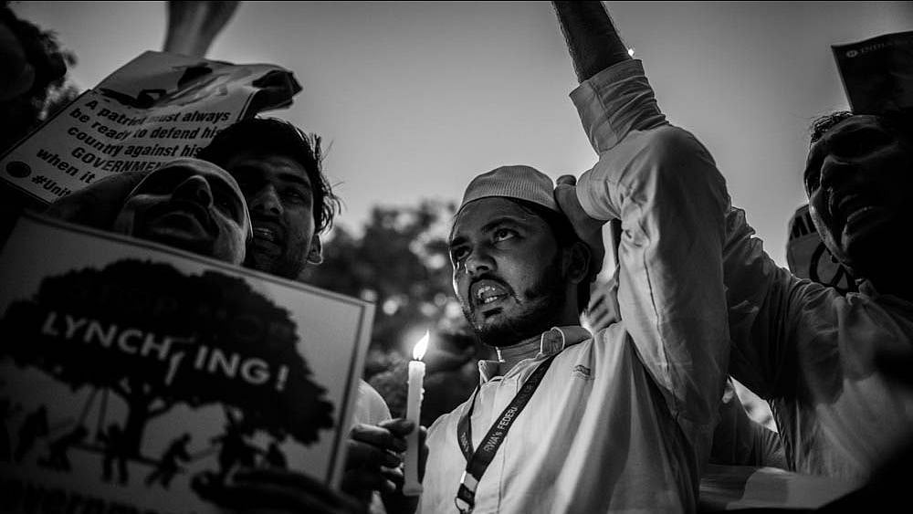 A man holds a candle to protest against the recent lynching of a 24-year-old in Jharkhand.&nbsp;