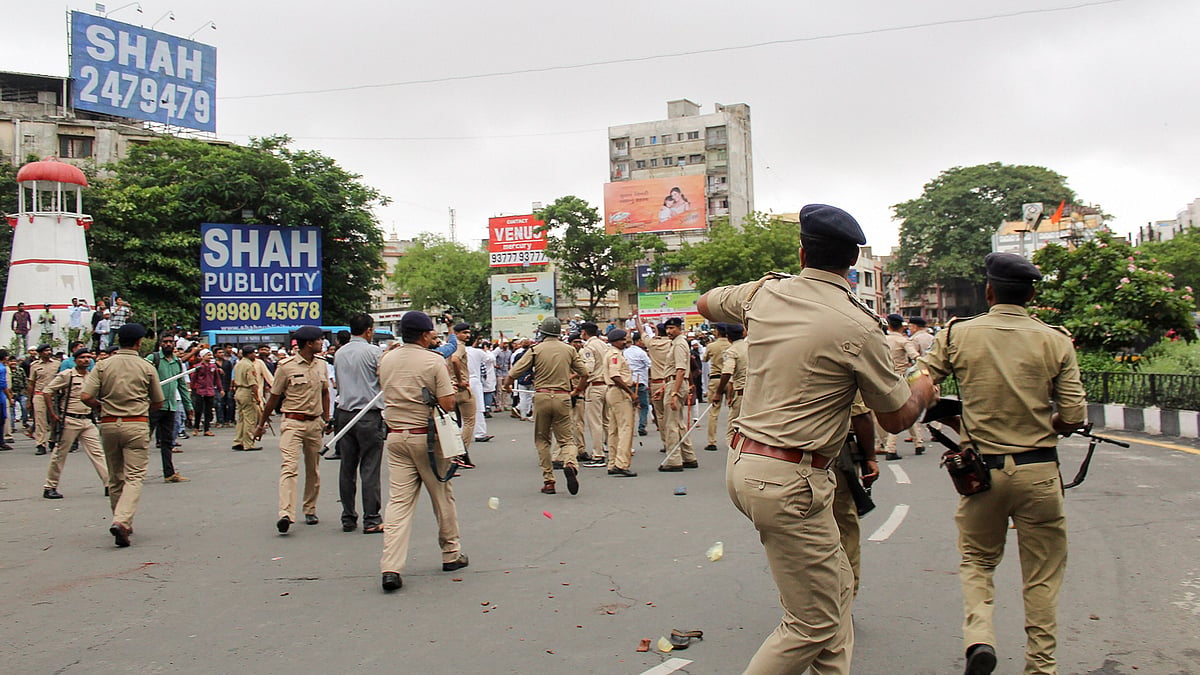 Policemen chase away protestors during a rally against incidents of mob lynching, in Surat on 5 July 2019. 