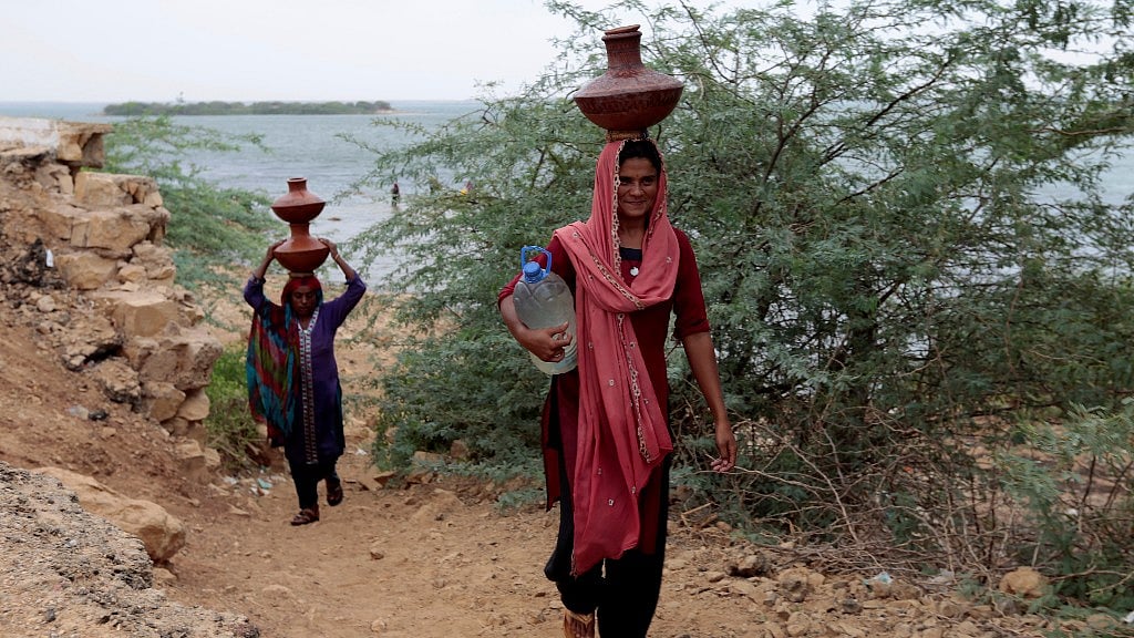 Women carry water home from Kalri lake in Thatta, Pakistan. Image used for representational purpose.
