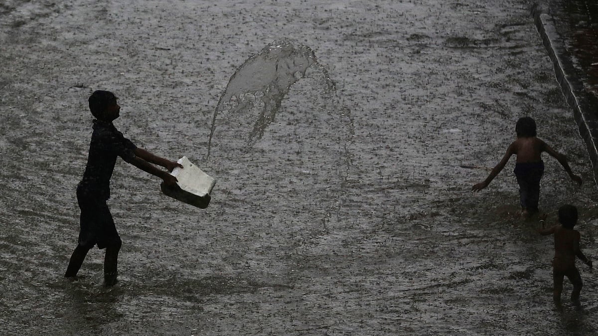 Children play at a waterlogged street during monsoon rains in Mumbai.