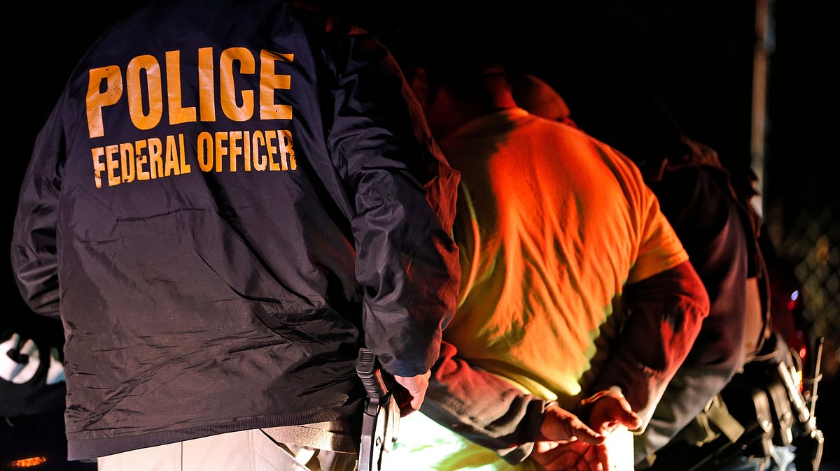 A file photo of US Immigration and Customs Enforcement agents detaining a person during a raid.