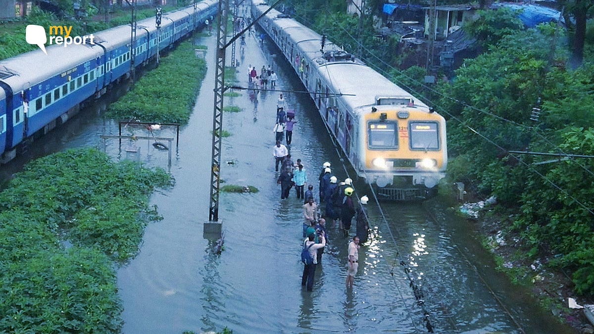 People walk on railway tracks as heavy rainfall disrupts railway service.