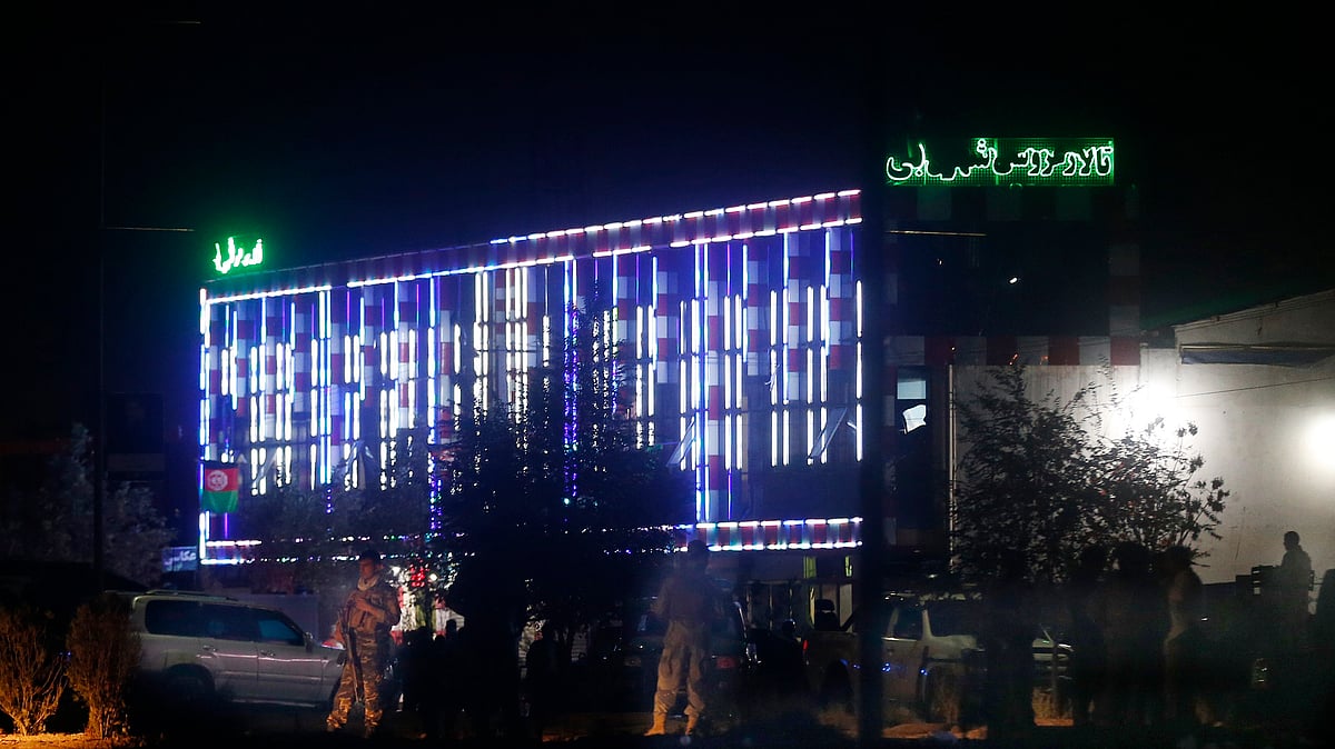 Afghan police men stand guard outside the wedding hall after an explosion in Kabul, Afghanistan.