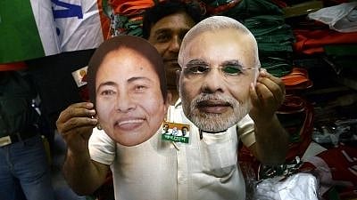 Kolkata: A shopkeeper shows the masks of Prime Minister and BJP leader Narendra Modi and West Bengal Chief Minister and TMC supremo Mamata Banerjee ahead of 2019 Lok Sabha elections, in Kolkata on 29 March, 2019. 