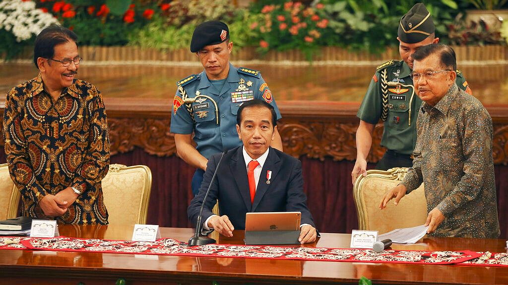 Indonesia President Joko Widodo, center, takes his seat before a press conference, at the palace in Jakarta on 26 August 2019. 
