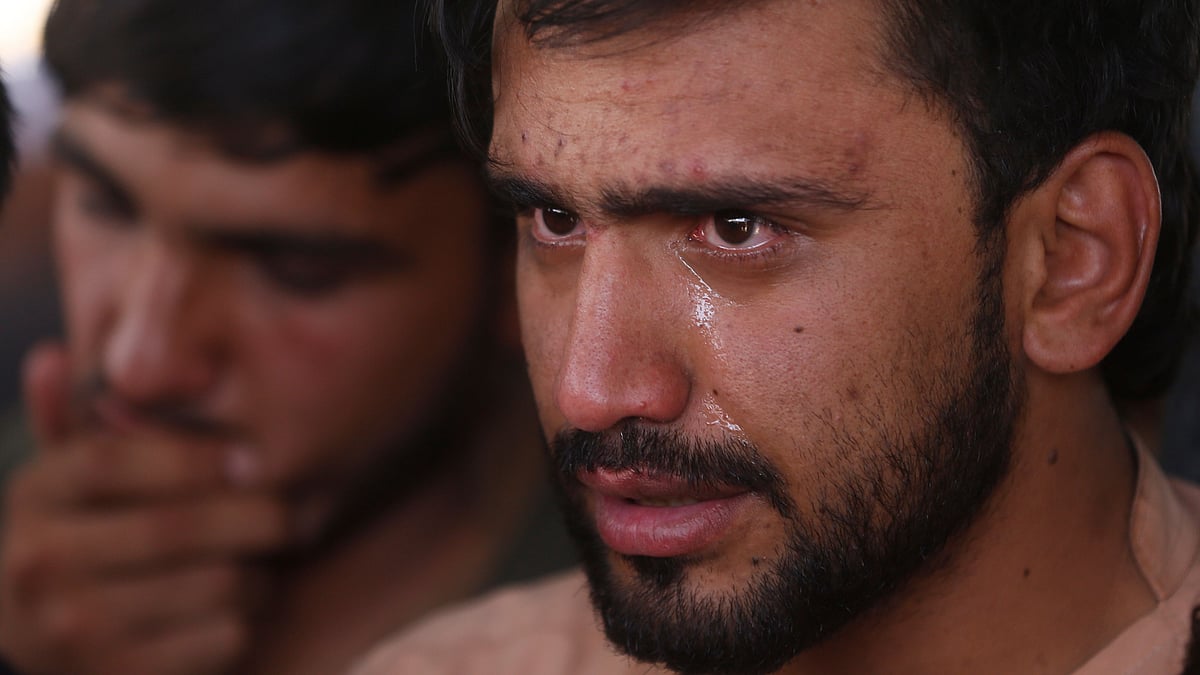 Relatives grieve near the coffins of victims of the Dubai City wedding hall bombing during a mass funeral in Kabul.