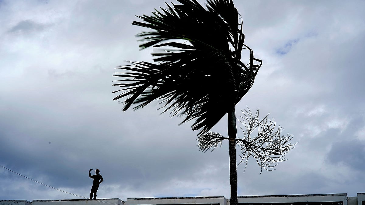 A man stands on a store’s roof as he works to prepare it for the arrival of Hurricane Dorian in Freeport on Grand Bahama, Bahamas.