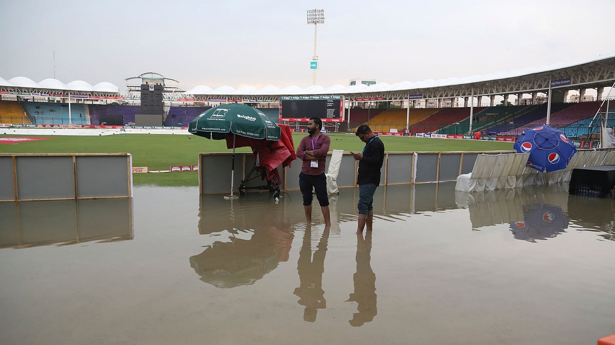 Officials stand at the National Stadium after rain in Karachi, Pakistan, Friday, Sept. 27, 219. Heavy rain has delayed the start of the first one-day international between Pakistan and Sri Lanka. 