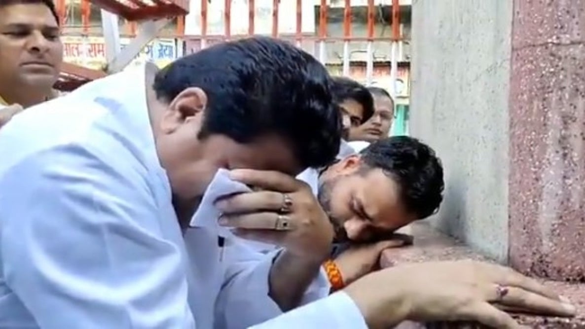SP Leader Firoz Khan cries in front of a Gandhi statue
