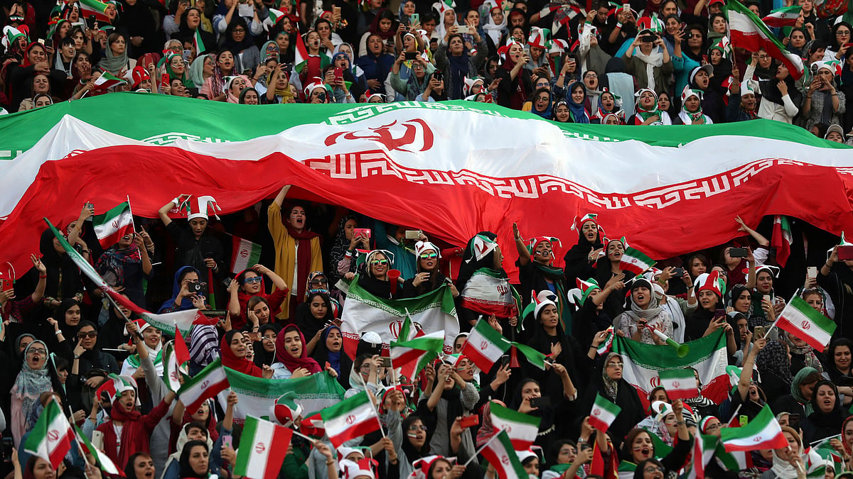 Iranian women cheer as they hold a huge Iranian flag during a soccer match between their national team and Cambodia in the 2022 World Cup qualifier at the Azadi (Freedom) Stadium in Tehran, Iran, Thursday, Oct. 10, 2019. 