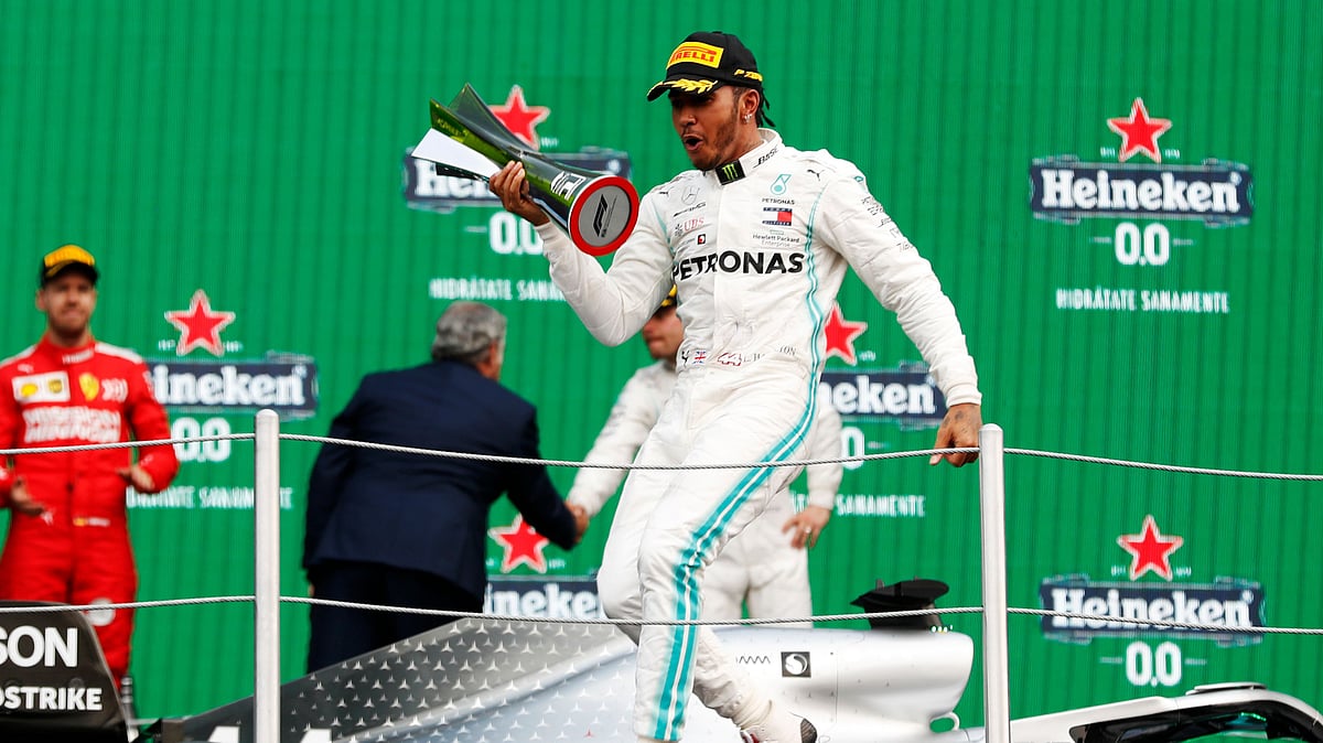 Mercedes driver Lewis Hamilton celebrates on the podium after winning