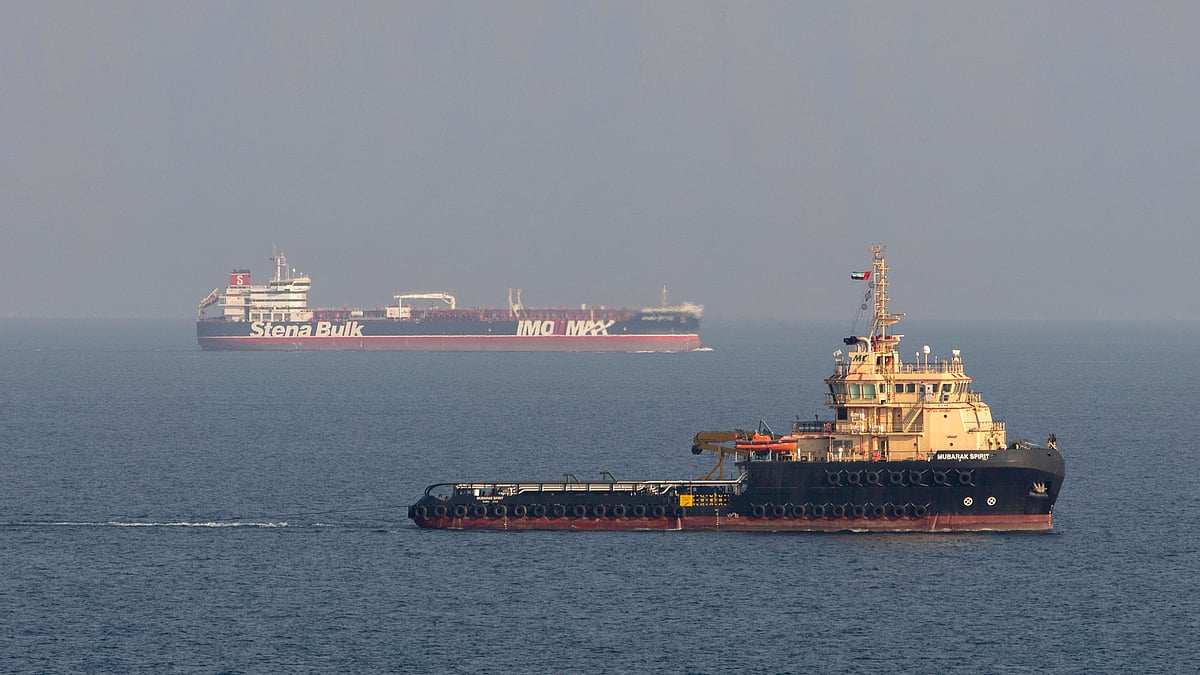 Royal Navy Wildcat helicopter patrolling the Gulf shows the MV Stena Impero, background, as it sails from the port at Bandar Abbas.
