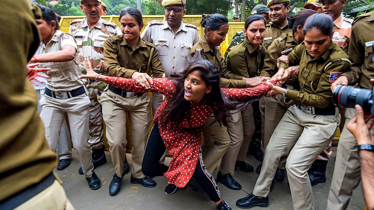 A student is detained by the police during a joint protest march by ABVP students.