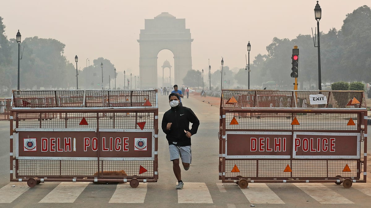 An Indian jogger wears a pollution mask early morning amidst light smog in New Delhi, India, Monday, Oct. 28, 2019. 