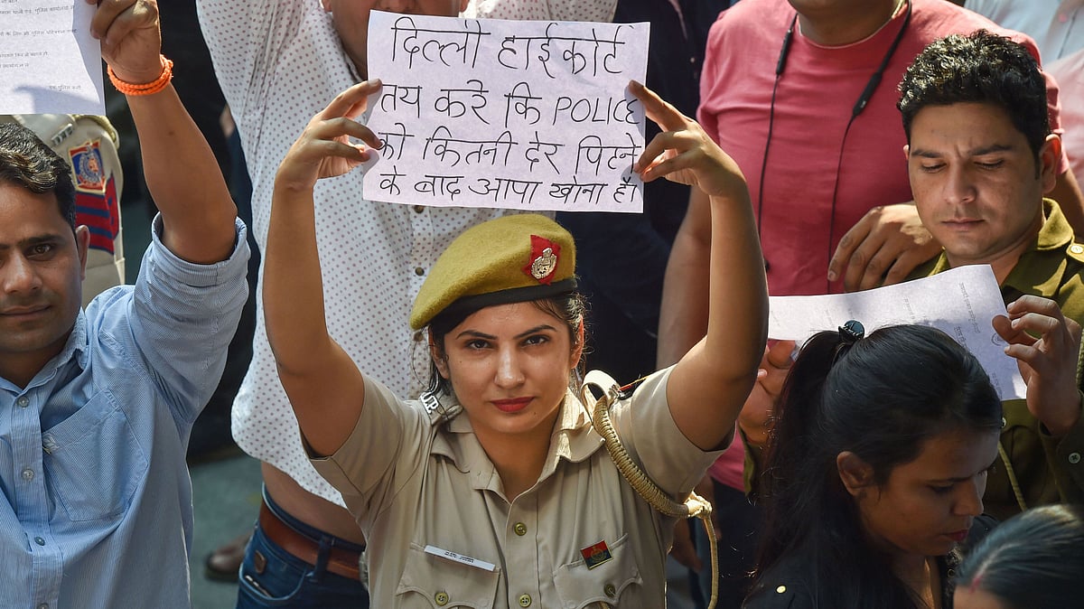 A Delhi Police personnel displays a placard during a protest on 5 November against the alleged repeated incidents of alleged violence against the police by lawyers. 