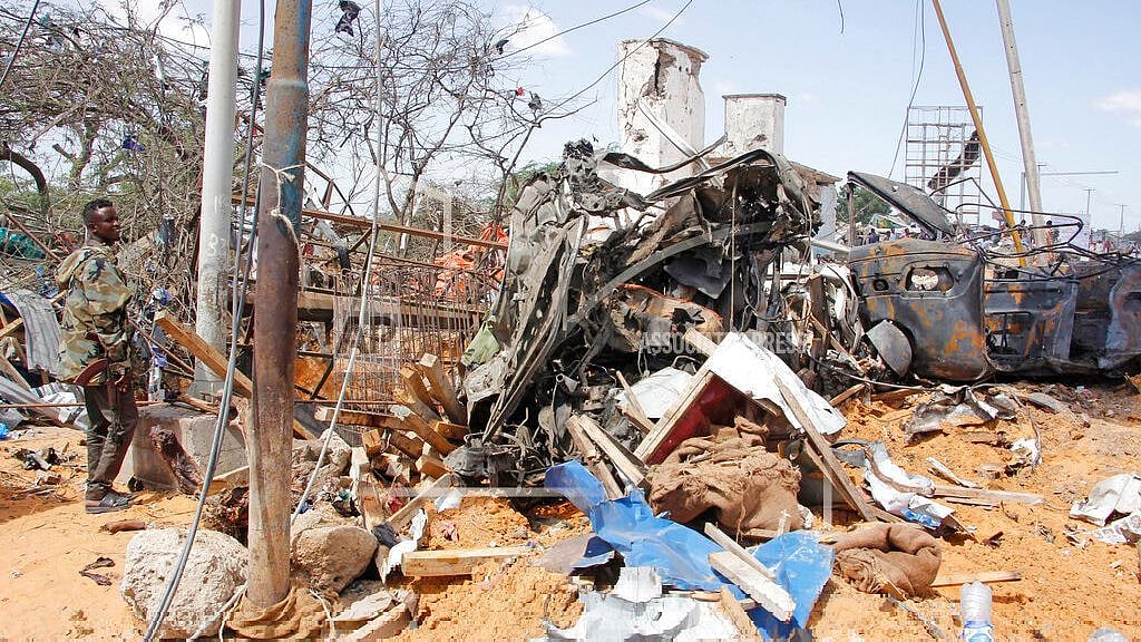 A soldier stands guard near wreckage of vehicles in Mogadishu after a car bomb in Mogadishu, Somalia, Saturday, 28 December 2019.