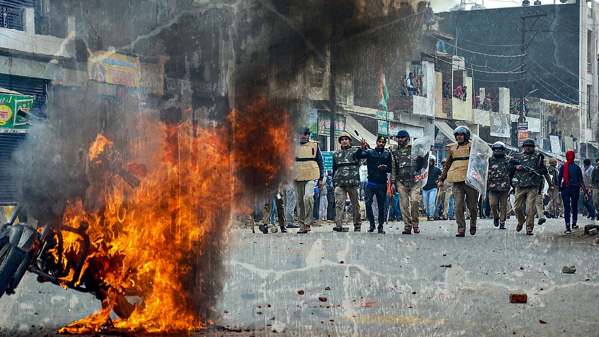 Smoke rises out of a burning vehicle during a protest against the CAA in Muzaffarnagar on 20 December.