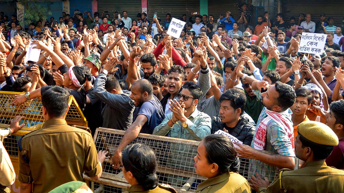 Police personnel stand behind a barricade as they attempt to stop protestors during a bandh called by North East Students Organisation (NESO) in Guwahati.