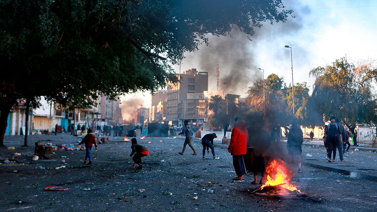 Protesters set fire to close a street during clashes between security forces and anti-government protesters near Baghdad’s Khilani square, Iraq, Sunday, 26, January.