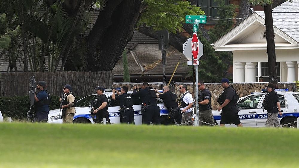 Honolulu police take up defensive positions with their weapons after a shooting and domestic incident at a residence on Hibiscus Road near Diamond Head on Sunday, Jan. 19, 2020, in Honolulu.