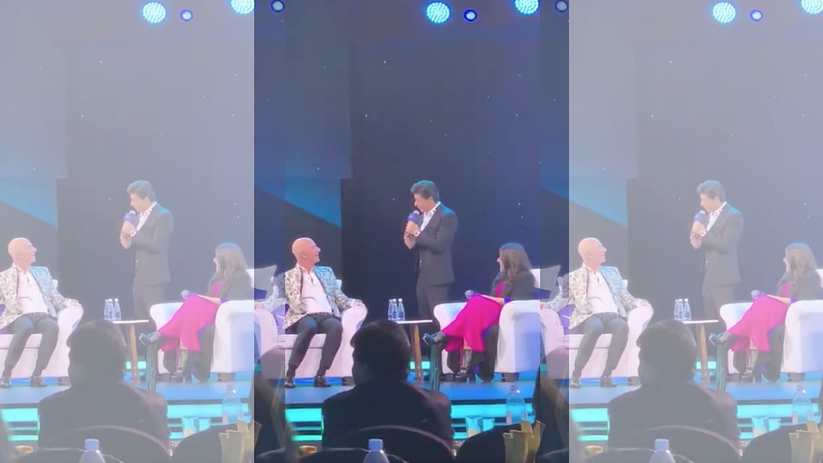 Shah Rukh Khan guides Jeff Bezos on stage while Zoya Akhtar looks on.