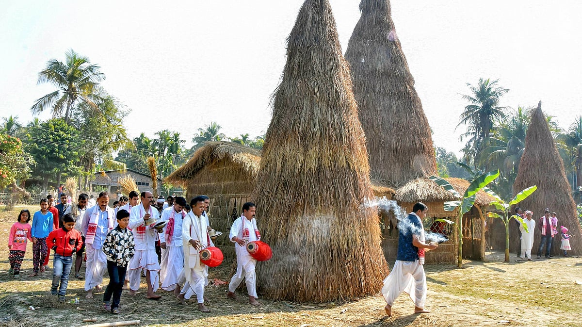 Residents perform rituals before setting ablaze a traditional bhelaghor or meji on the occasion of Magh Bihu, in Tezpur.